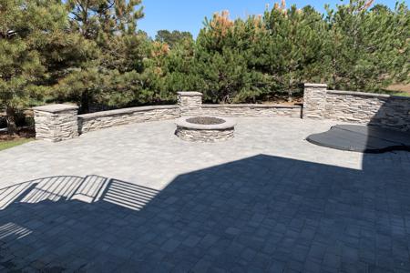 Veneer stoned fire-pit and sitting wall for this back yard in Monument, Colorado to go along with the paver patio