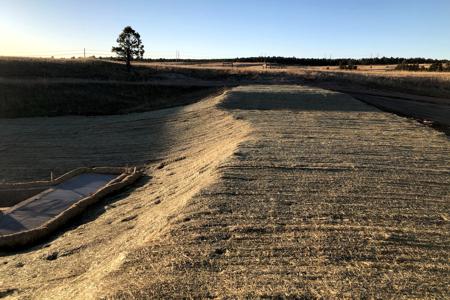 Erosion Control in Black forest, Colorado with the installation of erosion control blankets on the top of a pond access road so that we stop the erosion and get grass to grow