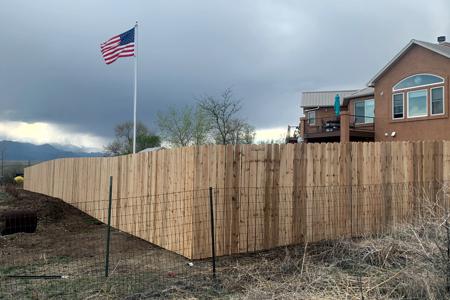 Privacy fence with Old Glory beautifully positioned in the background at a home in El Paso county Colorado