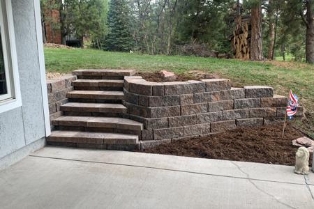 Segmental retaining wall with integrated stairs at a home in Monument, Colorado for erosion control and to allow access to the property