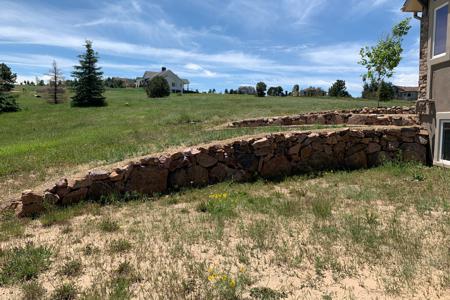 Pioneer granite retaining walls in Monument, Colorado for directing of water and for erosion control