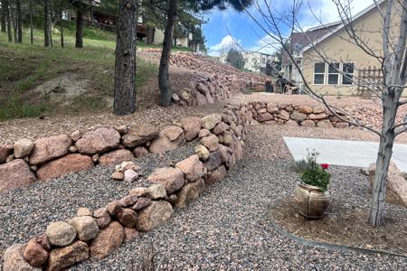 Retaining wall in Monument, Tri Lakes area. Installed a boulder wall to divert the flow of water to minimize the erosion