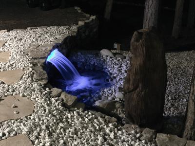 Pond-less water feature and the wood carved bear fishing in the water outdoor lighting in Black Forest Colorado